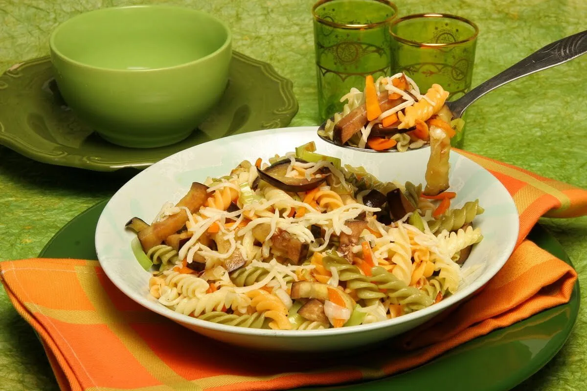 Legumes salteados com massa tricolor e queijo