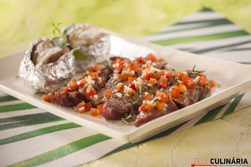 Vazia grelhada com molho de pimentos e batatas recheadas